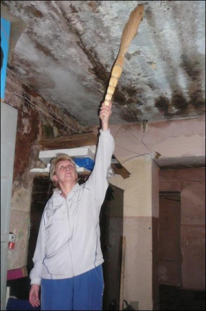 Ганна Івасюк, мешканка будинку по вулиці Сорохтея, 41, знімає зі стін грибок. Її донька та онуки переїхали жити до села