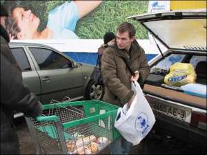 Житель Гомеля Дмитрий Залужный и его жена Оксана складывают покупки в багажник своей ”строи-восьмерки”. В черниговском гипермаркете ”Виско” они купили продуктов на 600 гривен. Так оплатят себе расходы на дорогу