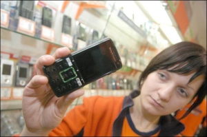 Оксана Бірюкова зі столичного магазину ”Мобілочка” показує телефон ”Соні Ерікссон К850” 