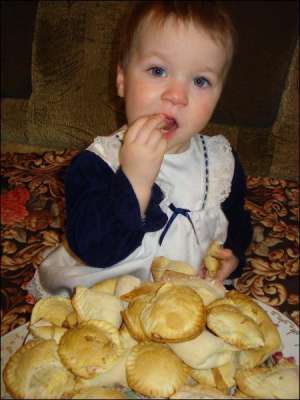 Полина Пушкаренко, которой год и три месяца, лакомится мамиными ”ракушками” с орехами. В такую выпечку можно добавлять изюм или мак, но детям виноград можно есть лишь после двух лет