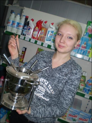 Продавец магазина ”1001 мелочь” Юлия Вирченко показывает горшок для фондю фирмы ”Бергофф” за 220 гривен