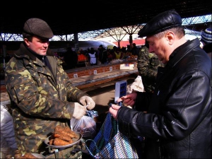 Олександр Юхименко (ліворуч) із міста Котельва на Центральному колгоспному ринку в Полтаві продає моркву пенсіонеру Адольфові Дзеві. Чоловік понад 15 років торгує овочами на ринку