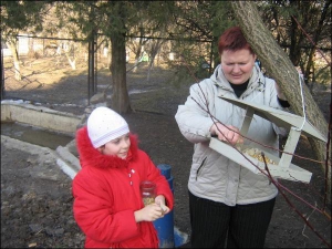 Керівник зоологічного гуртка еколого-натуралістичного центру Ірина Пугачова зі своєю вихованкою 8-річною Кариною Грищенко вішають на дерево годівничку для птахів
