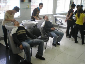 В академии парикмахерского искусства, на столичной улице Героев Днепра, киевлянину Юрию (слева) моют голову перед стрижкой и укладкой. Студенты академии обслуживают клиентов бесплатно