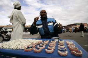 Дантист на вулиці міста Маракеш, що у Марокко, пропонує різні зубні протези 