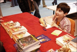 Шарль Антуан Кро, 9-річний француз, роздає автографи на своїй першій книзі ”Квітка лілії Нуармутьє”. Роман наймолодшого учасника ярмарки можна придбати за 7,60 євро. Головний герой книги — капітан Томас, який на своєму кораблі відправляється на чарівний о