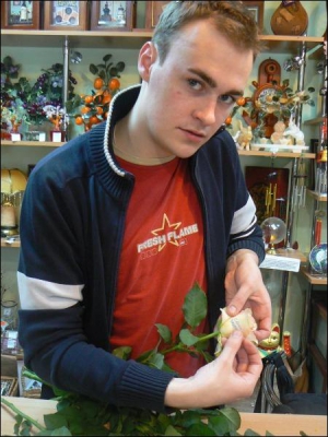 У магазині ”Квітковий рай”, що на вулиці Мазепи у Рівному, Максим Корнійчук клеїть на троянди вітальні написи до дня народження