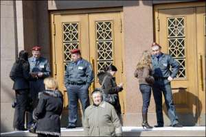 Охранники ЦУМа стоят в среду возле главного входа в магазин на Крещатике. Первых покупателей впустили внутрь около 15.00 