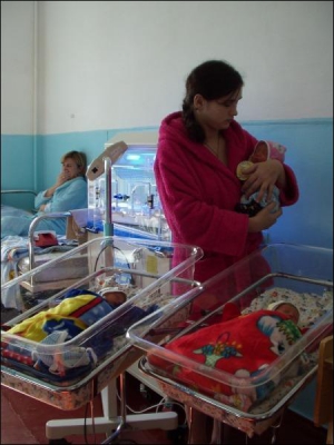 Марина Михайлова стоит в палате родильного отделения. Она держит на руках новорожденного братика Диму. Рядом стоят кроватки с ее детьми — девочкой Александрой и мальчиком Мишей. Дядя и племянники родились с разницей в один день. Мама Марины и бабушка двой