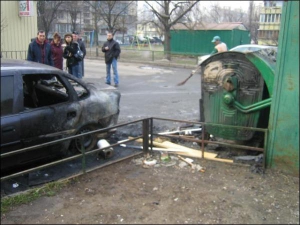 Соседи рассматривают во вторник утром сгоревший ”опель” во дворе на улице Бучмы на Березняках