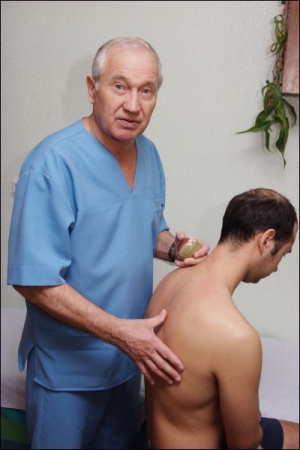 Столичний лікар Петро Бартош (ліворуч) оглядає пацієнта. У лікуванні він не використовує жодних медичних препаратів. За допомогою масажу впливає на больові згустки, які стали причиною порушень в організмі