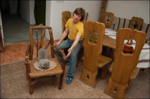 В домашней гостиной во Львове у художника Руслана Романишина есть образцы всей мебели собственного дизайна. Кот Романишиных лежит на стуле из коряг, который стоит 970 гривен
