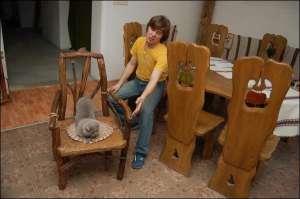 У домашній вітальні у Львові художник Руслан Романишин має зразки усіх меблів власного дизайну. Кіт Романишиних умостився на стільці з корчів, що коштує 970 гривень