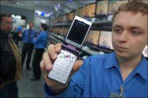 Сергей Присюда из магазина ”Юнитрейд” показывает телефон ”Сони Эрикссон W380і”. Мобилка рассчитана на молодежь. В комплекте есть стереонаушники