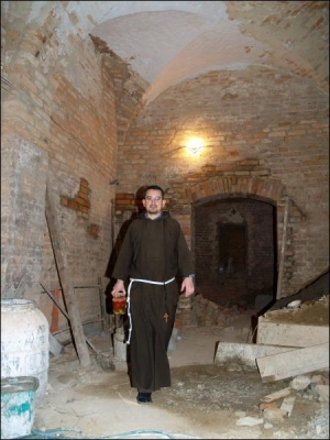 Брат Андрей Рудник в подземных ходах под капуцинским монастырем в Виннице несет банку с консервированными помидорами. Сейчас в подземельях монахи держат консервацию. Высота подвала — четыре метра. Здесь планируют сделать кафе