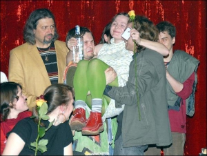 Білоруську поетесу Віру Бурлак тримає на руках її чоловік Віктор Жибуль (ліворуч) і глядач із залу. За Жиболем стоїть український поет Сергій Пантюк