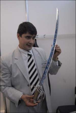 Мастер-оружейник из Луганщины Александр Ткаленко держит изготовленную собственноручно гусарскую саблю ”Ночной дозор”. Мужчина хочет продать ее за 50 тысяч евро