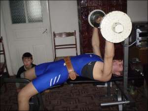 Чемпіон України Олександр Коляденко тренується вдома у вітальні. Брат Павло (ліворуч) підіймає 8-кілограмову гирю