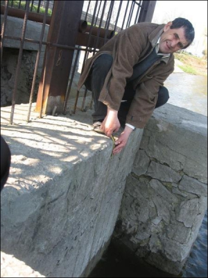 Завідувач господарства національного парку ”Софіївка” Віктор Побережний біля нижнього ставу. Чоловік показує, що рівень води спустився на п’ять сантиметрів