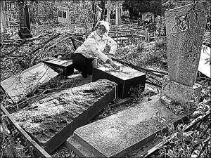 Виннитчанка Елена Мельничук около могилы своего деда на городском кладбище в микрорайоне Пятничаны. Сначала женщина думала, что памятники повалили вандалы. Ставить памятник на место ей бесплатно помогут рабочие фирмы, с которой ураганом сбросило крышу на 