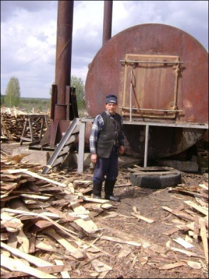 У селі Солотвине Шосткинського району Сумщини Василь Шолохман стоїть біля залізничної цистерни, яку пристосували для випалювання деревного вугілля