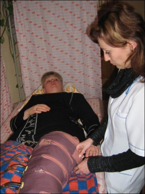 Медсестра Світлана Заник, 26 років, фіксує біорегулятор на нозі Лідії Свериди. За кілька сеансів жінка сподівається вилікувати ліву ногу
