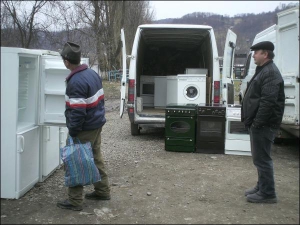 Житель села Дубового Тячівського району Закарпатської області Валерій (ліворуч) вибирає холодильник у Василя Візантія