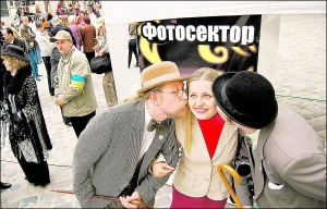 Экскурсоводы Иван (слева) и Петр Радковцы в костюмах львовских батяров заигрывают к девушке на площади Рынок