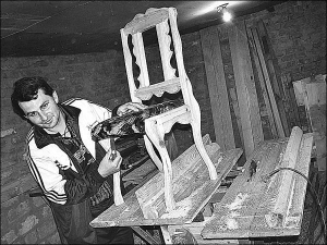 Юрій Дубина з селища Велика Багачка у майстерні прикручує ніжки до стільця. Чоловік  виготовляє на замовлення меблі з дерева