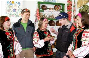 Варвара Сайфутдинова угощает коржами с маком швейцарских студентов Рафаэля Графа (справа) и Фабиана Детвилера. Ее подруга Мирослава Колесник в стилизованной горнице колледжа рассказывала ребятам об украинском быте