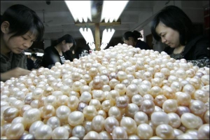 Працівниці ферми в китайському селищі Зюйю, провінція Женьянь, сортують річкові перлини. Молюсків тримають у проточній воді в штучних водоймах. Понад 70 відсотків вирощених перлів експортують