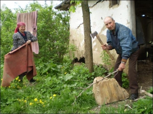 Михайло Данілєвіч із села Лісова Лисіївка Калинівського району на Вінниччині рубає хмиз, щоб розпалити у печі. Його сестра Ганна просушує рядна біля хати