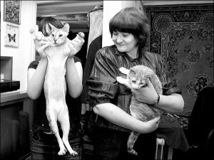 Тетяна Метельова (праворуч) тримає кішку Рижу. Жінка забрала тварину з двору, аби вберегти від можливої розправи