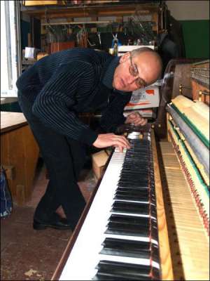 47-летний Олег Токар прослушивает звук пианино, в котором собирается подтягивать струны. На настройку одного инструмента мужчина тратит 6 часов