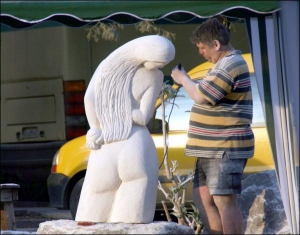 Житель Кам’янця-Подільського розглядає одну зі скульптур під час міжнародного симпозіуму скульпторів ”Петроманія-2008”