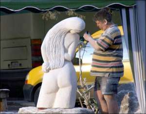 Житель Кам’янця-Подільського розглядає одну зі скульптур під час міжнародного симпозіуму скульпторів ”Петроманія-2008”