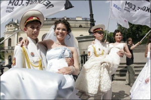 Лицеисты военного училища имени Богуна держат на руках 25-летнюю Александру Казакян (слева) и Ирину Соляр, 23 года, в среду возле Национальной филармонии на Европейской площади. Девушки незамужние, попросили богуновцев подержать их, чтобы сделать эффектно