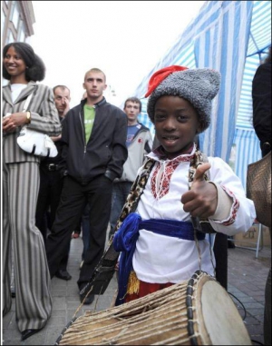 Одягнений у шаровари, вишиванку й папаху темношкірий хлопчик позує поблизу ЦУМу на Хрещатику в неділю, 25 травня. Його привів на святкування Дня Африки батько