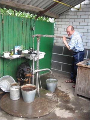 У Сосниці Микола Баклажко наповнює відра водою за допомогою ручної колонки. Чоловік зробив її тимчасово. На вулиці Яблуневій, де він мешкає із сім’єю, ніяк не підключать воду
