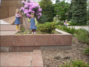 2-летняя Наталия Богун (справа) с 4-летней сестрой Еленой рассматривают экзотический рододендрон возле памятника Даниле Галицкому в центре города. Спереди видна большая яма на месте украденного растения