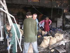 Рабочие очищают в пятницу утром помещение магазина ”Юбилейный” на просп. Победы от следов пожара