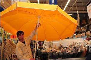 Роман Карпенко зі столичного супермаркету ”Метро”, що на проспекті Григоренка, 43, показує пляжну парасолю з діаметром купола 3 метри. Парасолі світлих відтінків купують найкраще