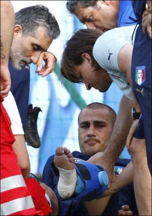 Фабио Каннаваро оставляет поле ”Зюдштадиона” в швейцарском Бадене во время тренировки. Он повредил икру после столкновения с Джорджио Кьеллини