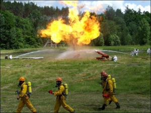 Працівники МНС гасять пожежу на навчальній газовій свердловині у Малій Рублівці на Котелевщині. Щоб охолодити метал, трубу з шістьох боків поливають водою. Потім потік спрямовують на вогонь, збиваючи полум’я при основі труби. Вогонь гасне. Лише тоді закру