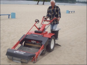 Моторист рятувальної станції Кременчука 55-річний Сергій Пашук показує, як італійська машина ”Кавалуччіо” очищує пісок. Очисник гуде, як трактор