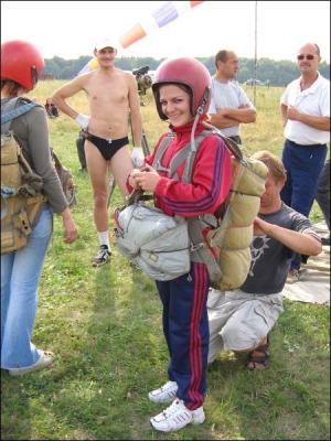 Винничанка Ольга Мазур, 21 год, на аэродроме в Сутисках в первый раз собирается прыгать с парашютом. Инструктор клуба проверяет снаряжение и закрепляет парашют на спине девушки. Для прыжков нужно иметь удобную обувь и одежду с длинными рукавами