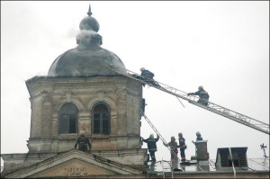 Фото зроблене через годину після удару блискавки. Баня історичної бібліотеки в Лаврі почала диміти вдруге, рятувальники піднімаються на неї, аби викинути тліючі рештки