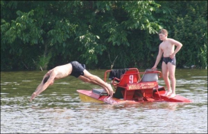 31-летний винничанин Дмитрий Бакуменко прыгает с катамарана на Вишенском озере в Парке дружбы народов. Его племянник 11-летний Владислав говорит, что на катамаране кататься веселее, чем на лодке
