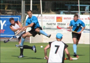 На вінницькому стадіоні гравець команди ”Олімпія” відбиває атаку ”Олімпіку”. Стадіон відкрили у центральному парку до Чемпіонату Європи у 2005 році. Його вважають найкращим в Україні для гри у хокей на траві
