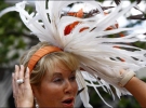 Глядачка кінних перегонів поправляє на сильному вітрі капелюшок з пір’я. Фото 17 червня 2008 року